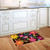 Spring Fling Doormat with colorful floral design on black background in a kitchen setting.