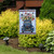Celebrate America Pickup Garden Flag with blue truck and patriotic design on decorative stand outdoors.