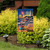 Oceanside Fireworks Garden Flag with beach scene, lighthouse, fireworks, and American flags on display outdoors.