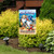 5 O'clock Beach Gnomes Garden Flag with colorful gnome design on a garden stand outdoors.