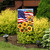 American Sunflowers Garden Flag with USA flag and sunflowers on a black metal stand outdoors.