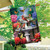 Spring Bath Birds House Flag with colorful birds, butterflies, and flowers on a garden flag outdoors.