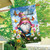 Springtime gnome house flag with colorful garden scene and butterflies on a blue cloudy sky background.