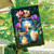 Be a Light Jars House Flag with lit candles and flowers on a garden flag outdoors.