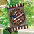 American Barn Star House Flag with patriotic star design and wreath on wooden background hanging outdoors.
