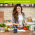 Organic Flow Flameless Candle on kitchen table surrounded by vegetables and kitchen utensils.