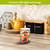 Sunset Parrot Flameless Candle, colorful parrot design, LED light, flameless candle on a wooden countertop.