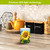 Sunflower Dance Flameless Candle with LED light technology on a kitchen countertop with tea and coffee.