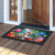 Spring Bath Birds Doormat with colorful floral design and birds on a wooden porch outside doorway.
