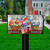Red White and Beautiful Mailbox Cover with floral baskets and patriotic design on a wooden background.
