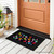 Black Rainbow Pawprints Mini Mat with colorful paw print design on front porch floor.
