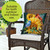 Birds in the Garden Indoor/Outdoor Pillow on a wicker chair with sunflowers and birds design.