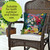 American Lemonade Indoor/Outdoor Pillow on wicker chair with floral design and white cushion.