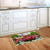 American Pickup Picnic Doormat with red truck design on wooden floor beside white kitchen cabinets.