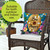 Happy Beehive Indoor/Outdoor Pillow with colorful floral bee design on blue background, brown wicker chair.