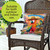 Sunset Parrot Indoor/Outdoor Pillow on wicker chair with tropical print and colorful parrot design.