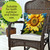 Sunflower Dance Indoor/Outdoor Pillow on a wicker chair with vibrant yellow sunflower and blue butterfly print.