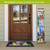 Welcome to Our Home Pine Reversible Porch Leaner with floral design standing by front door.