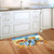 Welcome To the Beach Doormat with seashells and starfish on a kitchen floor beside sink.