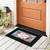 Black Bless This Home With Love Mini Mat with colorful floral design on front porch.