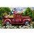 Red vintage truck with American flags and picnic supplies on a floral picnic comfort mat.