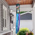 Be a Light Jars Windsock Wind Twister with colorful ribbons hanging from a porch roof outdoors.