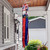 Saluting Gnomes Windsock Wind Twister, red blue and white gnome decoration hanging from wooden porch.