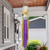 Yellow and purple Happy Easter Pickup Windsock Wind Twister hanging from a porch ceiling outdoors.