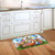 Springtime Bunnies colorful doormat with Easter eggs and bunnies on kitchen floor beside white cabinets.