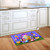 Happy Easter Egg Basket colorful doormat on kitchen floor with purple and blue checkered background.