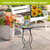 Black metal Fluttering Butterflies Plant Stand with colorful top and pot holding small green plant outdoors.