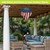 Wooden American Flag Hot Air Balloon Spinner hanging from a pergola in an outdoor seating area.