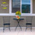 Butterflies and Daisies medium planter on a small black metal table with two matching chairs outside.