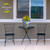 Briarwood Lane Goldfinches and Hydrangea medium planter on black metal table between two chairs.