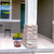 American Flowers Medium Planter with vibrant yellow flowers on a decorative pot on a porch.