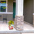 Briarwood Lane Flamingo Pair Medium Planter with yellow flowers on a home's porch area.