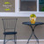 Briarwood Lane Sunflower Duo Small Planter with yellow flowers on a black metal table and chair.