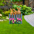 Garden Bunnies Metal Art with pink tulips on gray fence, brown bunnies, and green grass background.