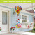 Cardinals and Sunflowers hot air balloon spinner with colorful design and red ribbons hanging outdoors.