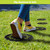 Hummingbird Rubber Stepping Stones, black with green hummingbird design, under person's feet on grass.