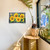 Large LED canvas art with checkered background and vibrant yellow sunflowers on a white wall.