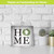 Metal mini moment home decor with wreath on white wooden background next to small potted plants.