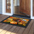 Wild Turkey and Pumpkins doormat with black border on a wooden porch outside an open door.