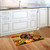 Wild Turkey and Pumpkins doormat on wooden floor in front of white kitchen cabinets.