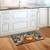 Fall Feathered Friends Doormat on wooden floor in front of white kitchen cabinets with autumn design.