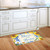 Bless This Home Floral Doormat with sunflowers and blue text on a colorful kitchen floor mat.