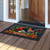 Cardinal and Holly doormat with vibrant red birds, holly, and welcome text on wooden porch.
