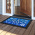 Let It Snow Snowflakes Doormat, blue with white snowflakes and gold text on black border.