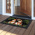 Snowman Pair Doormat with festive design and snowman duo on a black background with greenery.