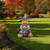 Halloween Pumpkin Stack Metal Art decoration with carved pumpkins and broom on green grass outdoors.
